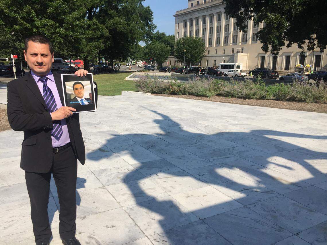 Exiled Venezuelan prosecutor Pedro Lupera holds a photo of his jailed protege, Luis Sánchez, on July 29, 2019. Lupera stands in front of a statue in Washington, D.C., of Simón Bolívar, the Venezuela-born liberator of much of South America.