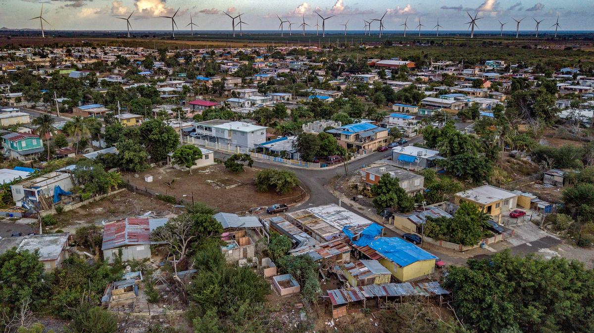 A year after Hurricane Maria struck the island, blue tarps are seen covering the roofs of homes near Coamo, Puerto Rico. It took 11 months to get electricity back on throughout the island, and the grid is just as decrepit as before the storm.