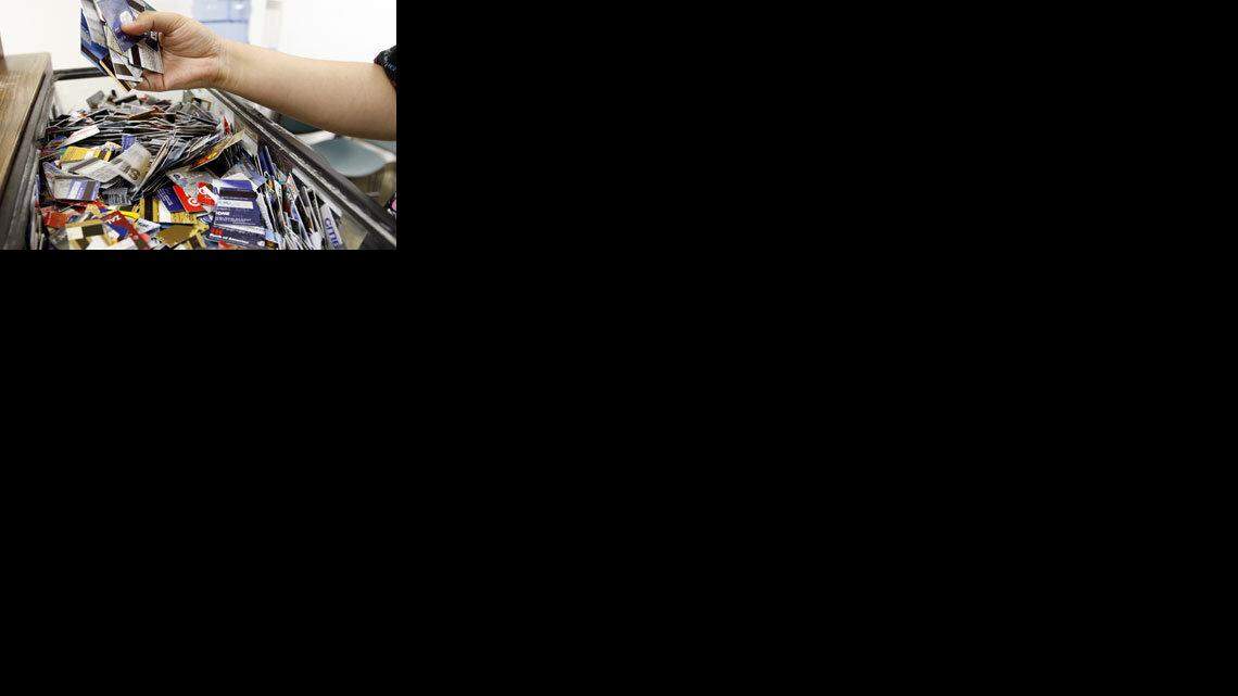 Cynthia Uribe looks for a credit card she cut-up at the Consumer Credit Counseling Service office in San Jose, California, Thursday, September 11, 2008. (Nhat V. Meyer/San Jose Mercury News/MCT)