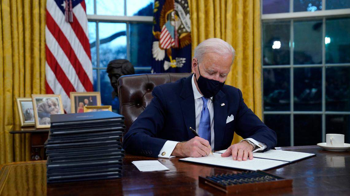 President Joe Biden signs his first executive order in the Oval Office of the White House on Wednesday, Jan. 20, 2021, in Washington. Biden plans to sign a "Buy American" executive order on Monday. (AP Photo/Evan Vucci)