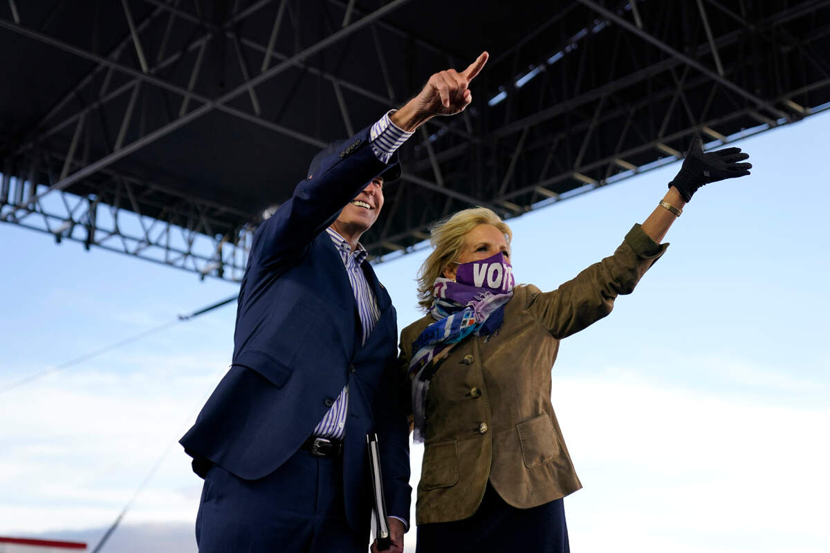 Democratic presidential candidate former Vice President Joe Biden points as his wife Jill Biden waves during a campaign event at Dallas High School in Dallas, Pa., Saturday, Oct. 24, 2020. (AP Photo/Andrew Harnik)