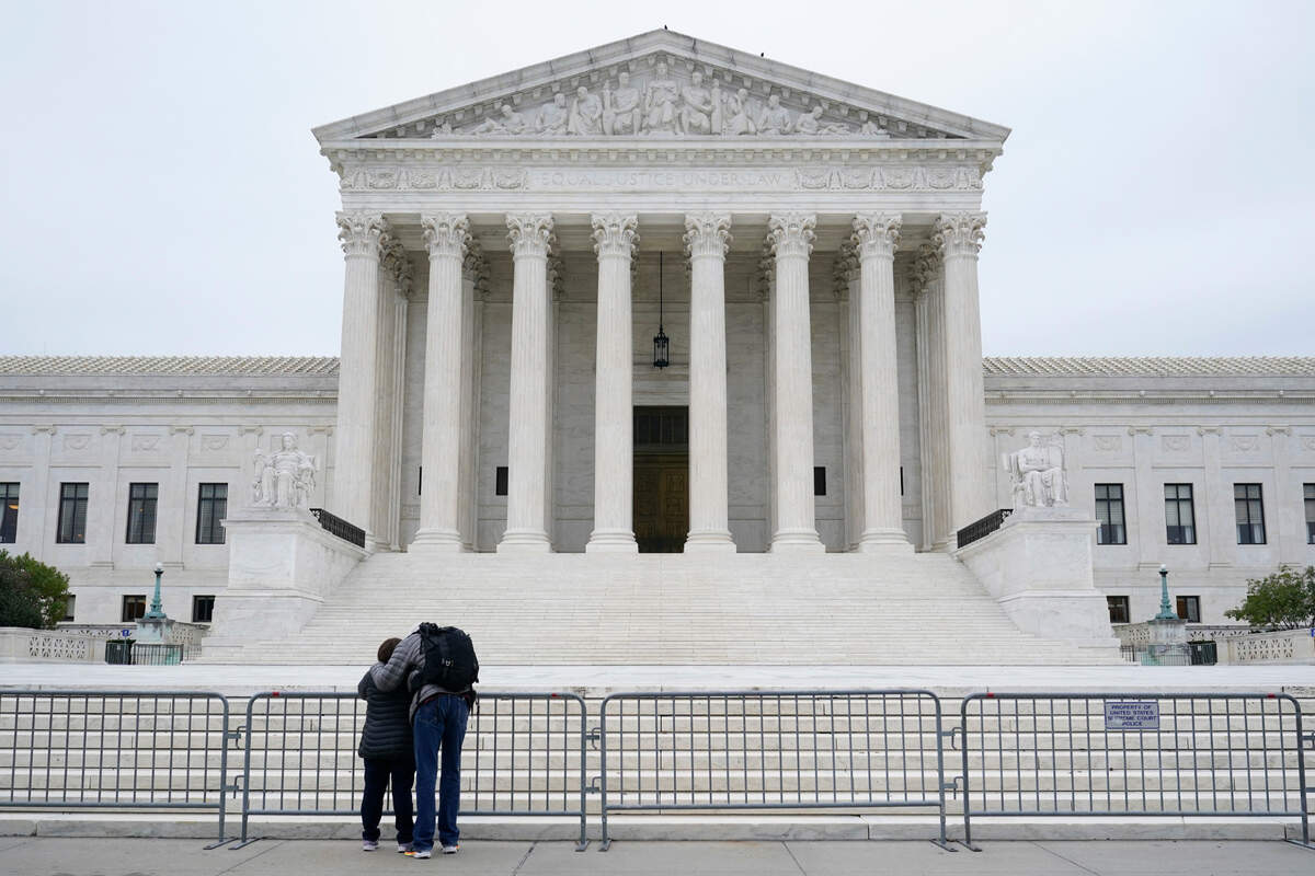 A woman and man pray outside the Supreme Court on Capitol Hill in Washington, Tuesday, Oct. 27, 2020, the day after the Senate confirmed Amy Coney Barrett to become a Supreme Court Justice. (AP Photo/Patrick Semansky)