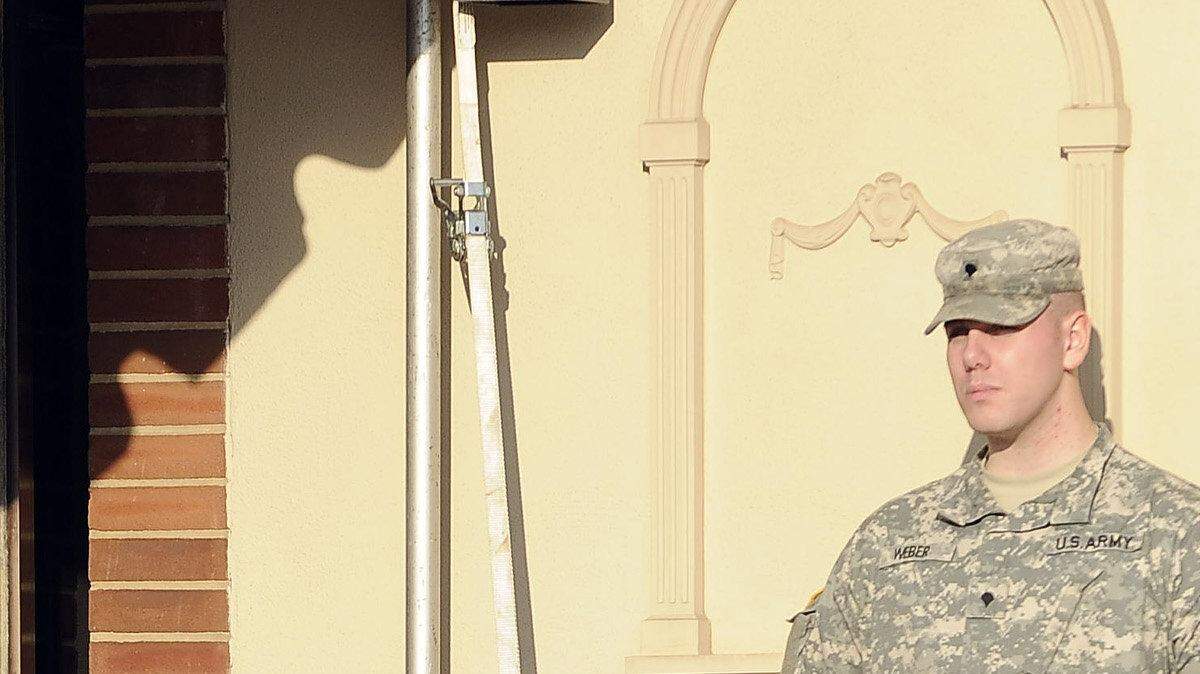 Military police stand guard outside the courthouse.