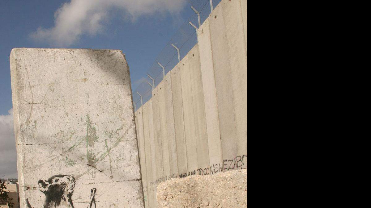 Artists add works every day to "Santa's Ghetto," an ongoing collaborative graffiti project near Bethlehem in the West Bank. A rat holding a slingshot, painted by the British graffiti artist Banksy, looks up at the separation wall.
