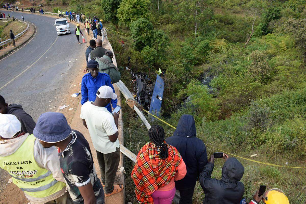 People look at the wreckage of a bus that plunged into Nithi bridge on Sunday, in Tharaka Nithi county Meru, Kenya, Monday, July 25, 2022. (AP Photo/Dennis Dibondo)