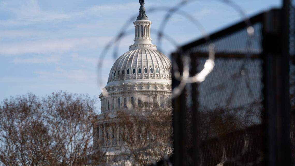 The U.S. Capitol is seen through a fence with barbed wire during the impeachment trial of former President Donald Trump at Capitol Hill in Washington, Tuesday, Feb. 9, 2021. (AP Photo/Jose Luis Magana)