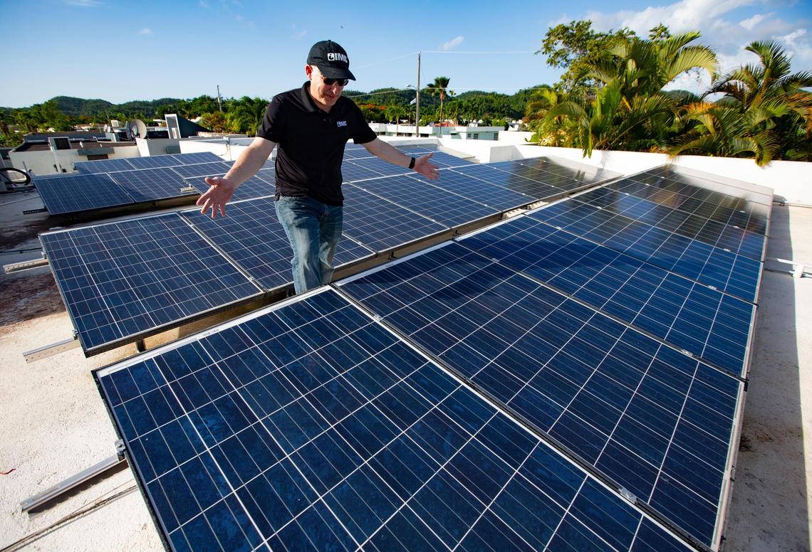 Engineer Israel Melendez stands on the roof of his home covered in solar panels in Manatí, Puerto Rico. More affluent Puerto Ricans have paid out of pocket for nanogrids, which typically provide power to a single home or building.