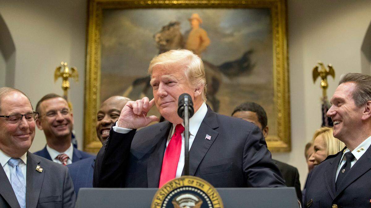President Donald Trump points to his ear and says, “Did I hear the word bipartisan?” as he announces his support for the First Step Act in the Roosevelt Room of the White House in Washington, Nov. 14, 2018.