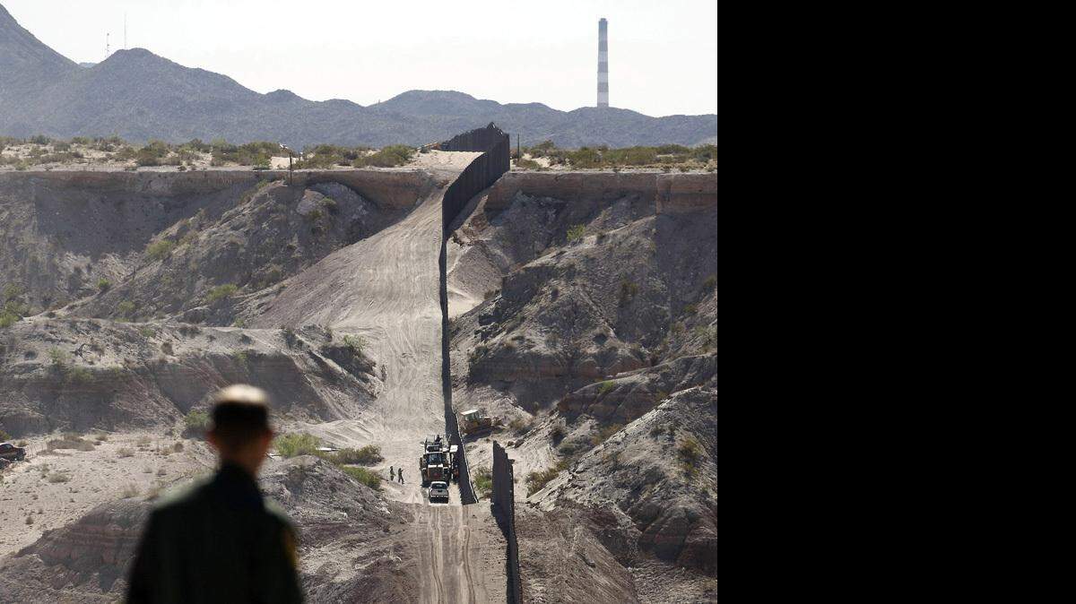 A Border Patrol agent looks along a new section of pedestrian barrier fencing near Sunland Park, N.M.