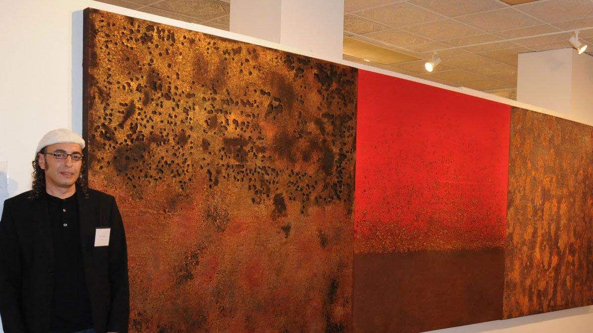 Sami Alkarim stands next to his artwork at the Fort Collins Museum of Contemporary Art. Alkarim, a former Iraqi political prisoner, is among a growing number of refugees who have been barred from getting permanent residency in the United States because of a broad interpretation of post-Sept. 11 laws. Alkarim, who was tortured almost every day for three years in a prison run by Saddam Hussein, can't get his green card because of work he did as a teen-ager for the same political party that counts the current prime minister of Iraq as a member. (MCT)