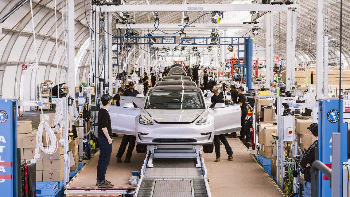Workers assemble the Tesla Model 3 on the production line line at Tesla’s factory, in Fremont, Calif., on June 28, 2018. Tesla could benefit from tariffs on foreign-made vehicles, since it is the only U.S. auto company that assembles all if its cars in the United States. But the upstart company depends on foreign-made auto parts, and possible tariffs on those parts could increase costs for consumers of Tesla and other U.S. car manufacturers.