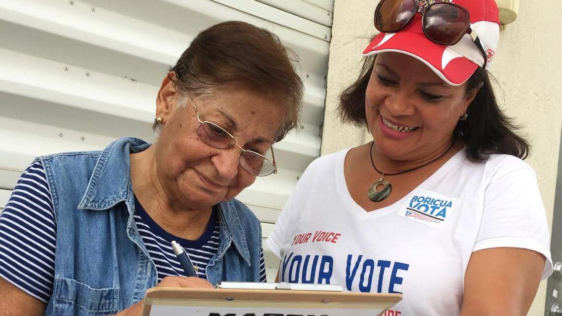In April 2018, Marisol Zenteno, right, from the League of Women Voters, helps with registering Aida Merced Lopez, who moved to Miami from Puerto Rico in April 2017, before Hurricane Maria ravaged the island.