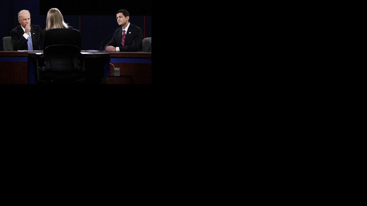 Joe Biden and Paul Ryan listen to moderator Martha Raddatz.