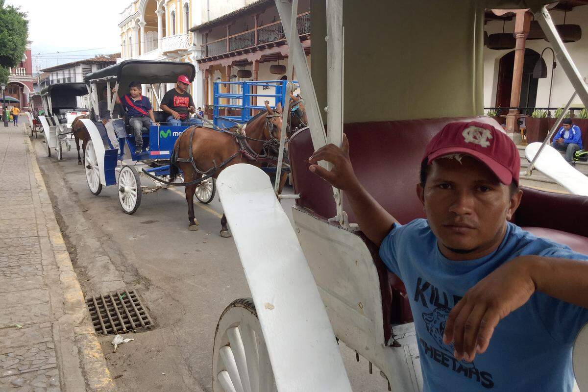 A dramatic slump in tourism has left little work for the drivers of the traditional horse-drawn carriages in the colonial city of Granada in Nicaragua, says Osmán Guadamuz, seen here seated in his empty coach on July 27, 2018.