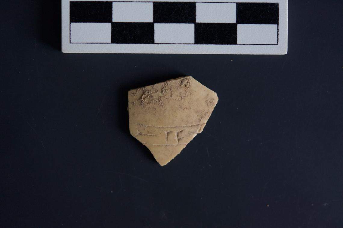 A fragment of ostrich egg shell with cuneiform carvings.