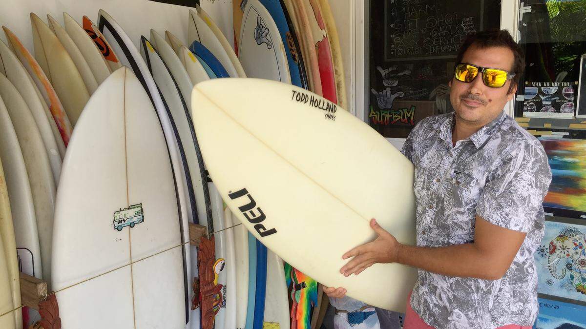 César Rueda holds a board outside his Stop and Go Surf Market in Playa Colorado, Nicaragua, which he says has ‘an amazing beach break, a world-class wave.’ But unrest in Nicaragua has been a hard blow to tourism, he adds.