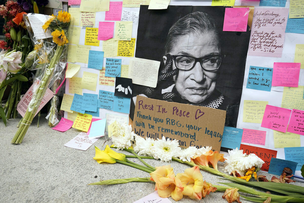 A memorial to U.S. Supreme Court Justice Ruth Bader Ginsburg includes a photograph of the late Justice, Tuesday, Sept. 22, 2020, outside the Harvard Law School library at Langdell Hall, on the campus of Harvard University, in Cambridge, Mass. Ginsburg, who attended Harvard law school but transferred to Columbia, died Friday, Sept. 18, 2020, at the age of 87. (AP Photo/Steven Senne)
