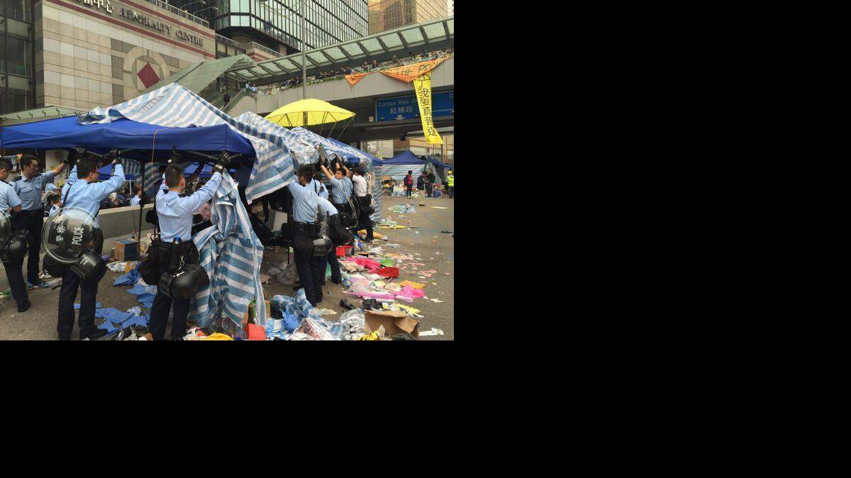 Police take down shade structures and tents at the main Hong Kong protest site in China on Thursday, Dec. 11, 2014. Pro-democracy protesters have occupied the Admiralty site, near government headquarters, for more than two months. Most protesters departed without resistance Thursday as police carried out a court order to clear the site.

