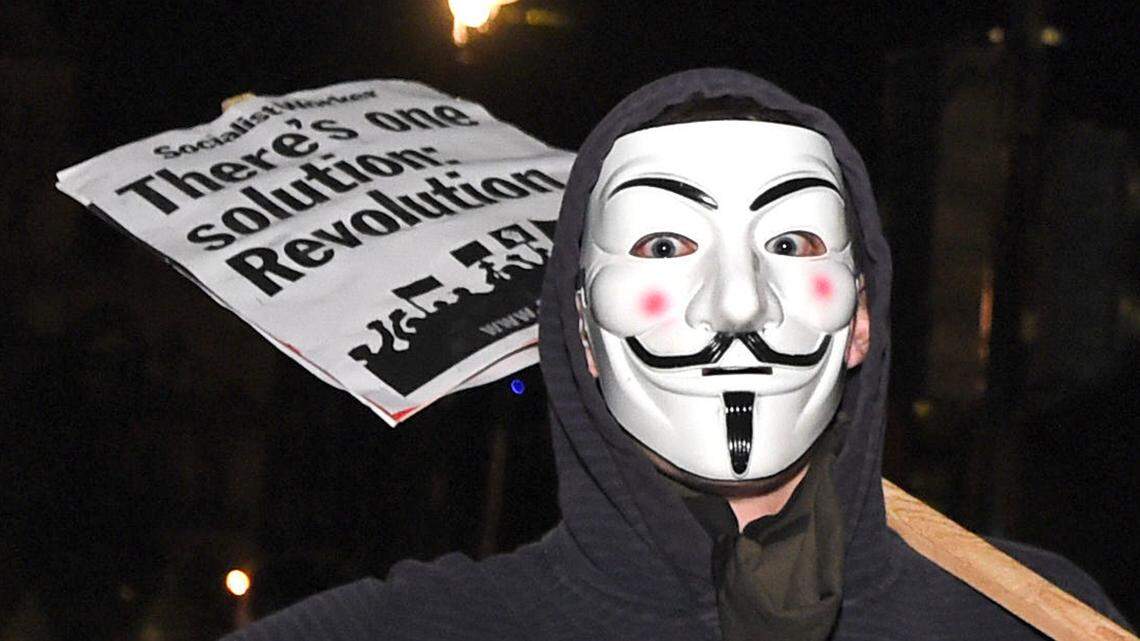 A protester joins others demonstrating near the Houses of Parliament in central London, during the Million Mask March bonfire night protest organized by the Anonymous hacker collective on Nov. 5, 2016.