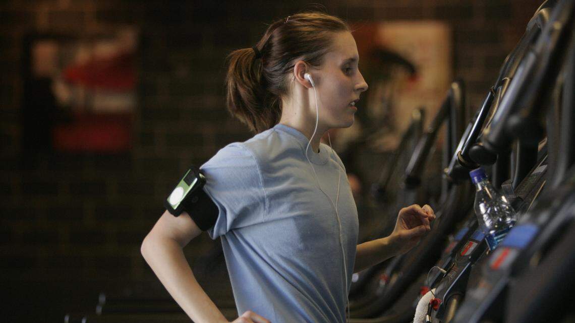 Lindsay Sawyer wears a pair of earbuds during her workout at Capital Fitness in Raleigh on Thursday, March 16, 2006. Starting this week, all 30 McClatchy markets are pleased to introduce an audio version of all your local news