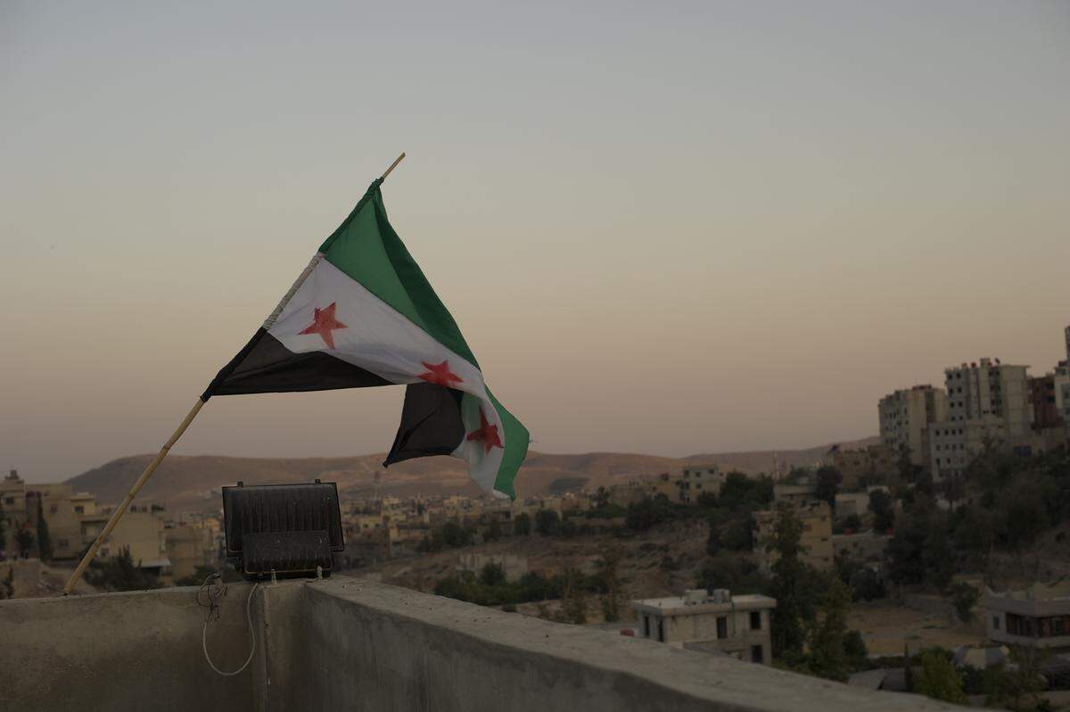 From Altal, Syria, the three-starred revolutionary flag flies atop a government position moments after its capture by rebel forces.