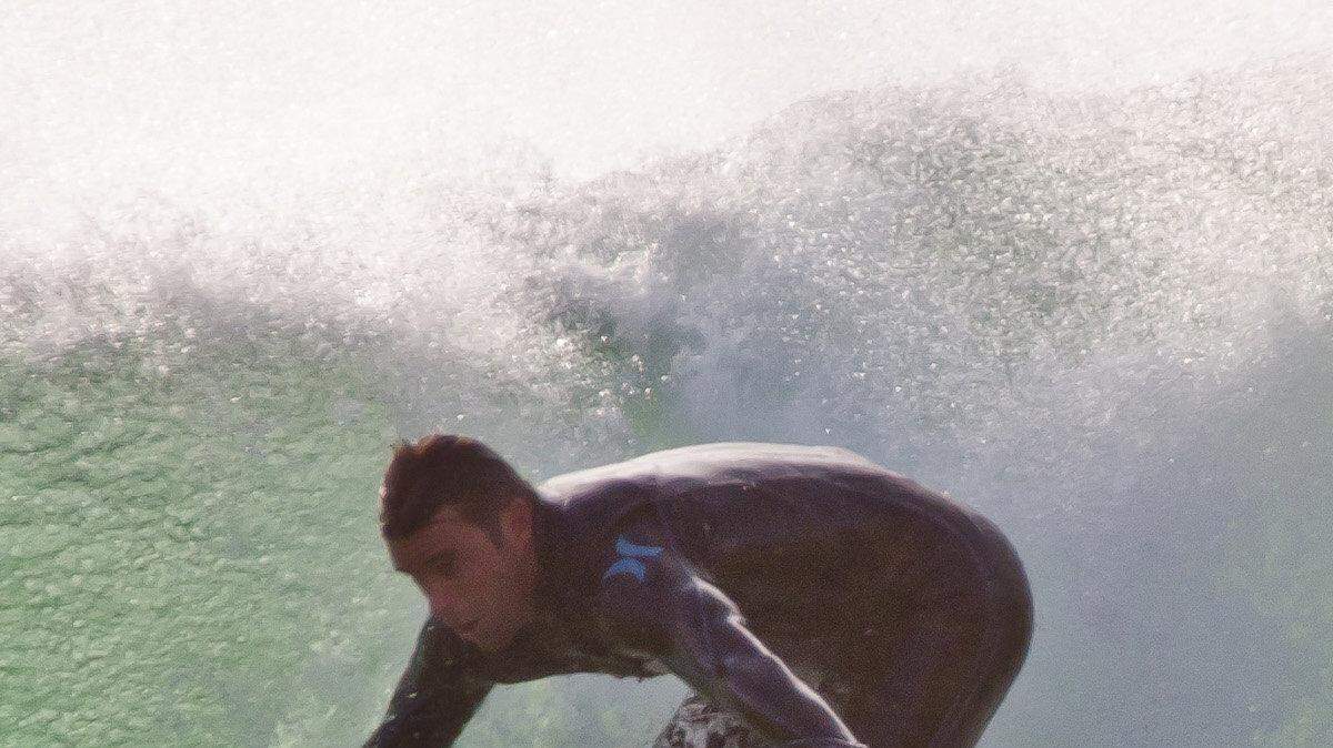 A surfer rides a wave off the coast of Lladudno, South Africa. Surfers say they feel threatened by the great white sharks attracted by cage diving companies for the benefit of tourists.