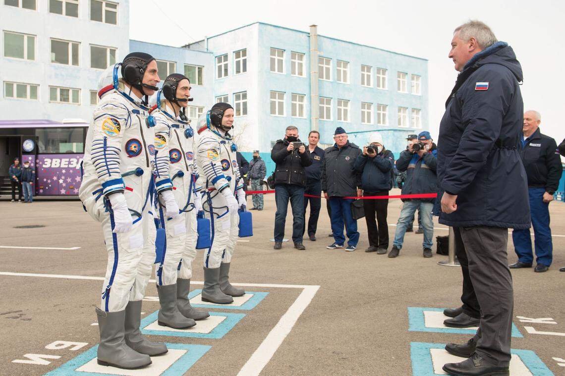 Expedition 63 crew members Chris Cassidy of NASA, left, and Anatoly Ivanishin and Ivan Vagner of Roscosmos report to Roscosmos Director General Dmitry Rogozin, right, as they depart building 254 for the launch pad, Thursday, April 9, 2020 at the Baikonur Cosmodrome in Kazakhstan.