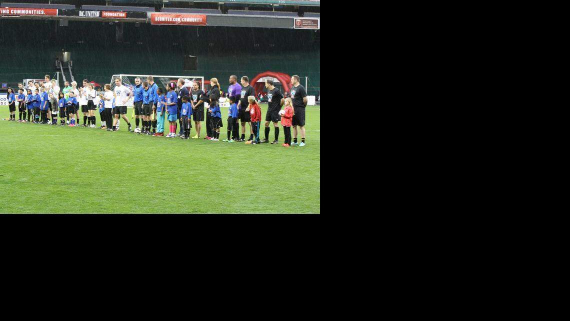 Democrats, Republicans and soccer stars stand side by side with U.S. Soccer Foundation kid participants before the start of the Capital Soccer Classic congressional match, April 14, 2015.
