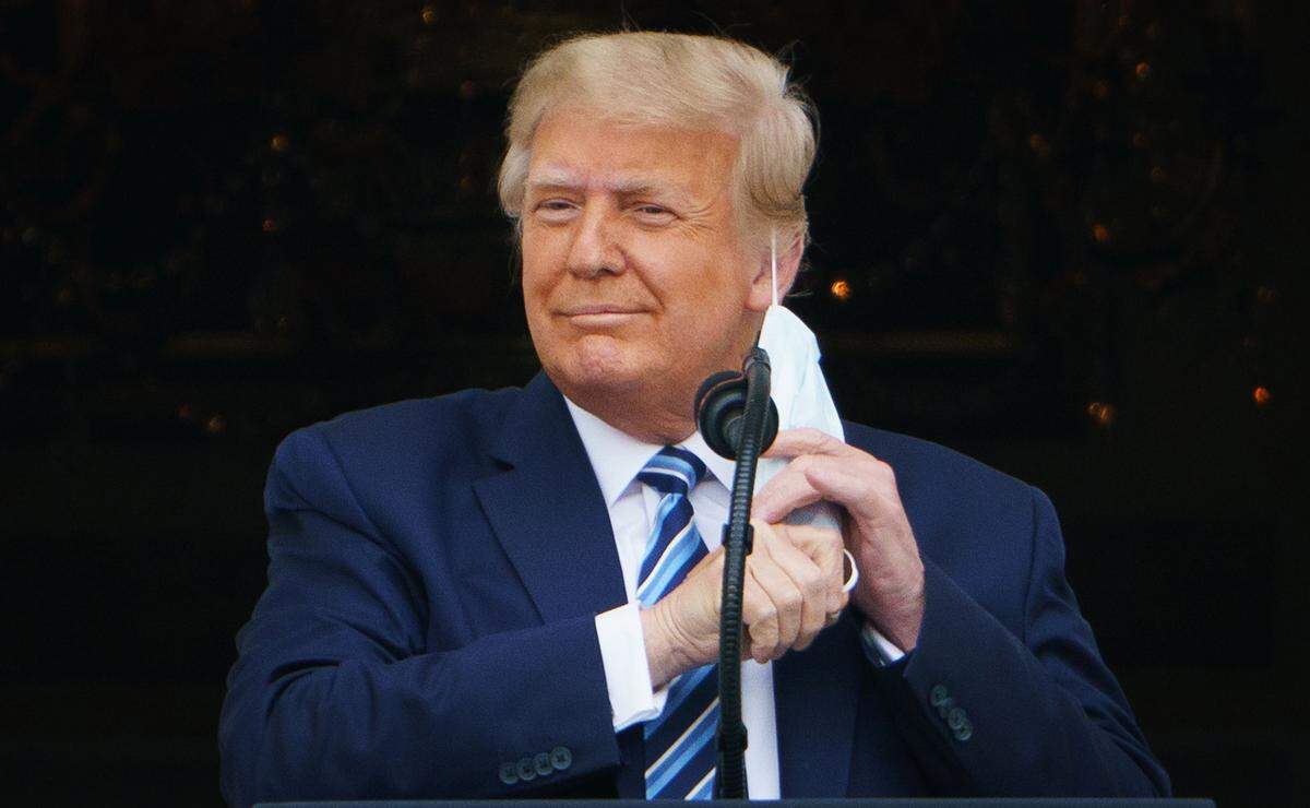 President Donald Trump takes his mask off before speaking at a rally from the South Portico of the White House in Washington, D.C. on Oct. 10, 2020.