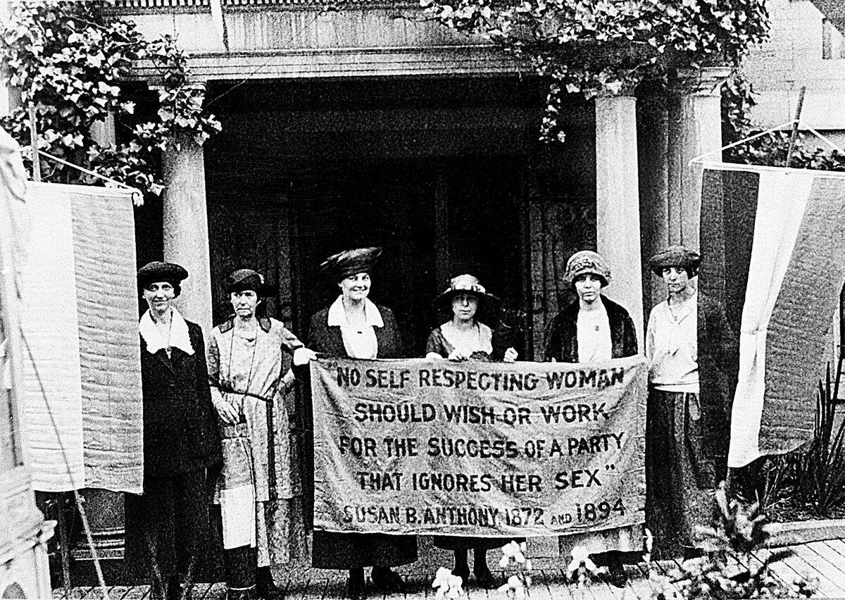 FILE - In this June, 1920 file photo, Chairwoman Alice Paul, second from left, and officers of the National Woman’s Party hold a banner with a Susan B. Anthony quote in front of the NWP headquarters in Washington. President Donald Trump says he’ll pardon Susan B. Anthony, a leader in the women’s suffrage movement, who was arrested for voting in 1872 in violation of laws permitting only men to vote. Trump is trying to curry favor with women voters. (AP Photo)