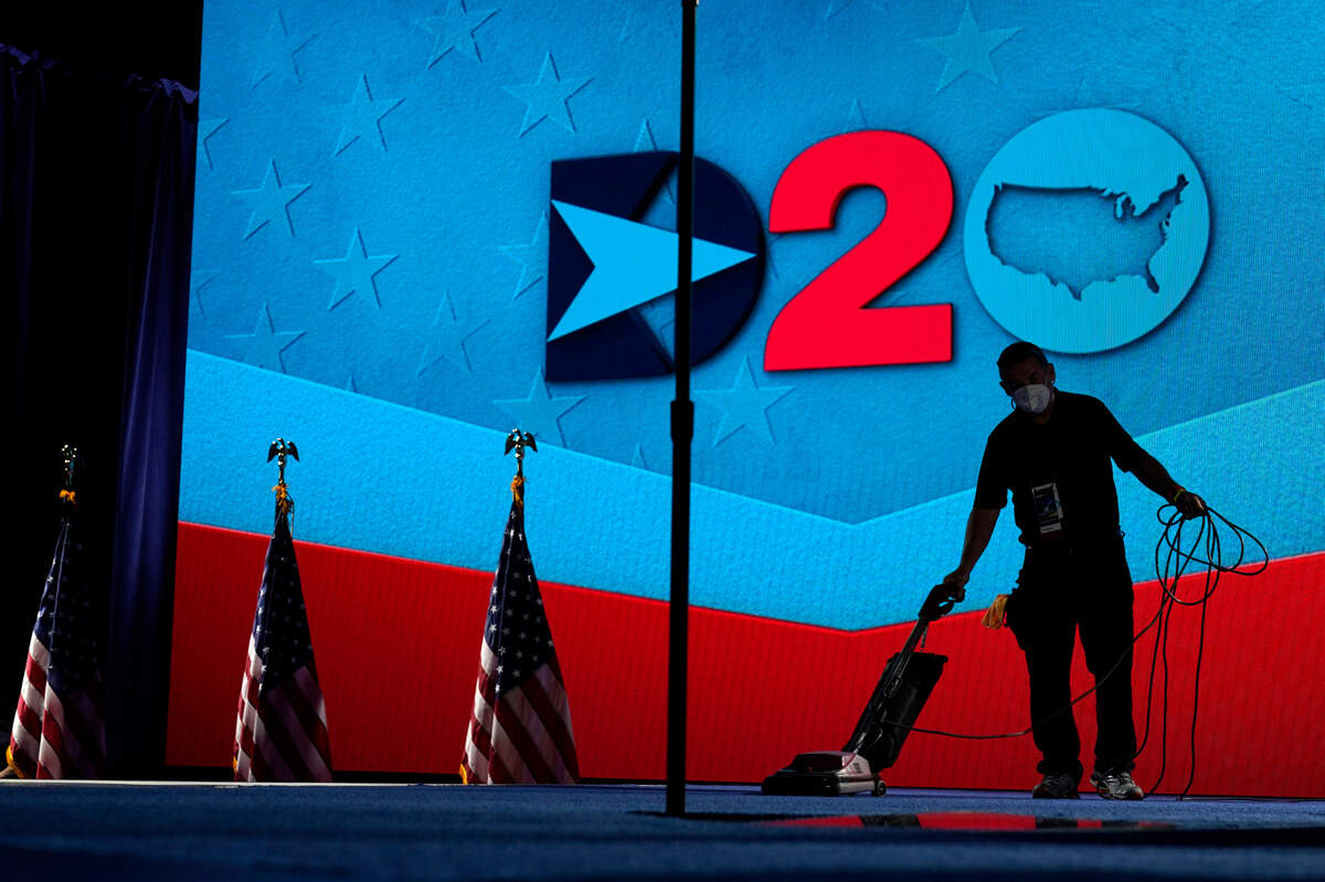 A worker vacuums the stage where Democratic vice presidential candidate Sen. Kamala Harris, D-Calif., will speak on third day of the Democratic National Convention, Wednesday, Aug. 19, 2020, at the Chase Center in Wilmington, Del. (AP Photo/Carolyn Kaster)