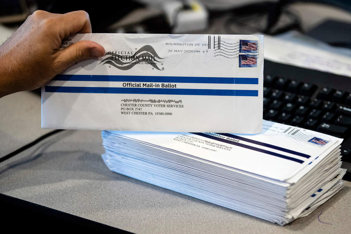 FILE - In this May 28, 2020, file photo, mail-in primary election ballots are processed at the Chester County Voter Services office in West Chester, Pa. Pennsylvania officials said Friday, July 31, 2020, the state will foot the cost of postage for voters to mail in ballots in November’s general election, a move that Gov. Tom Wolf has made a priority as the coronavirus pandemic unexpectedly fueled high interest in voting by mail under a new state law. (AP Photo/Matt Rourke, File)