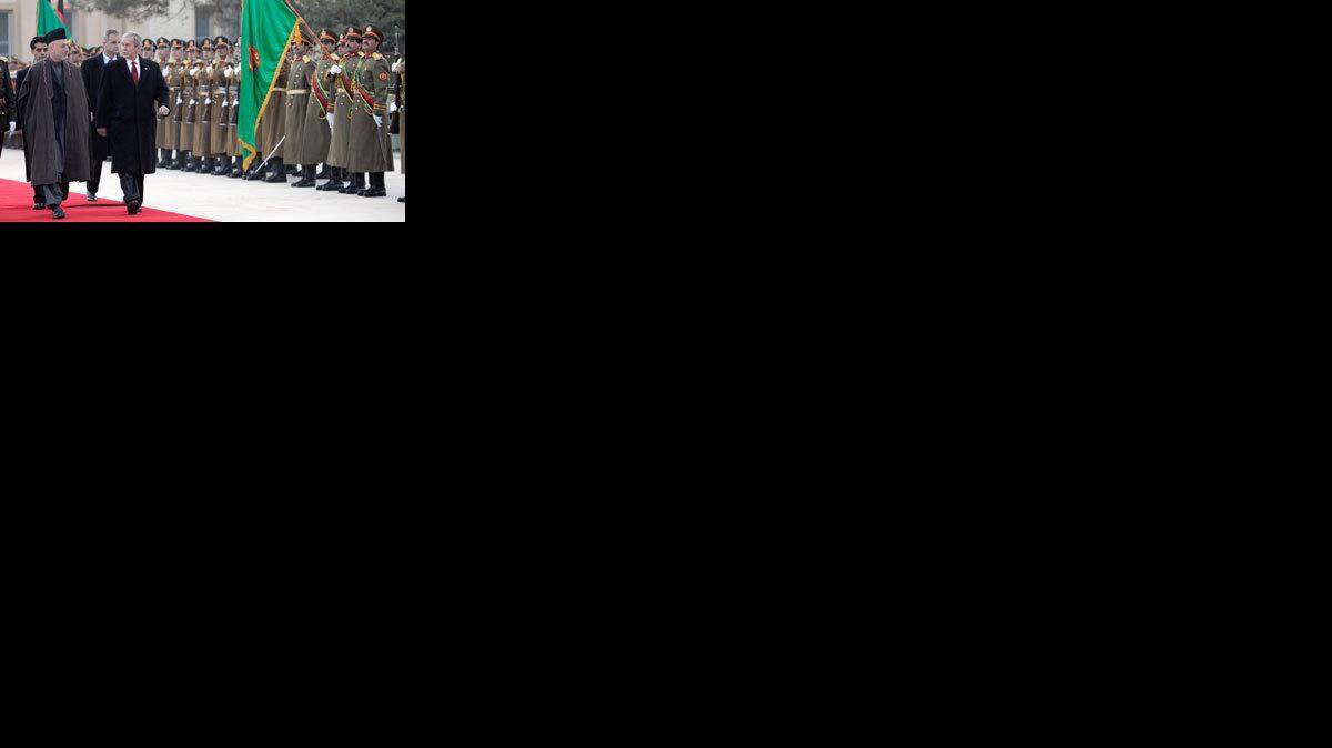 President George W. Bush walks with Afghan President Hamid Karzai on Dec. 15 in Kabul.