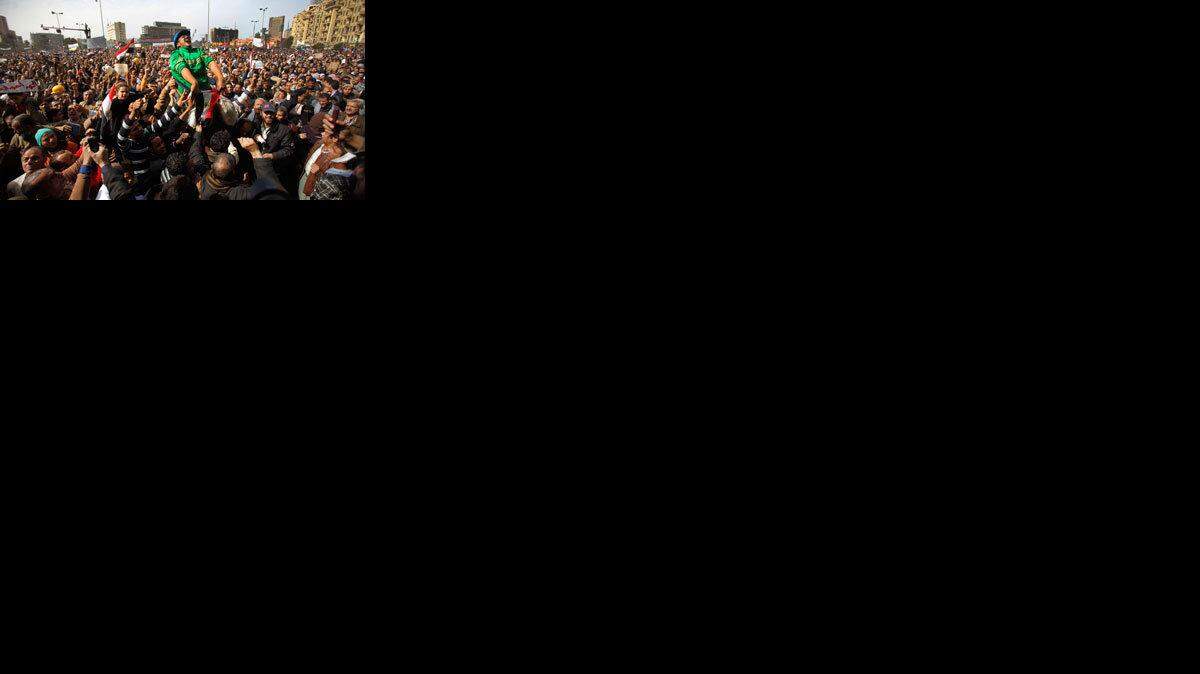 Amr Ibrahim is lifted up in his wheelchair by the anti-government protestors after noontime prayers in Tahrir Square.