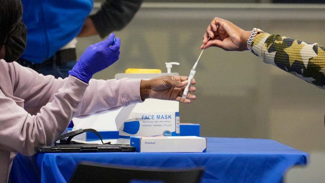 In this Nov. 24, 2020, file photo, a traveler places a swab in a tube after self testing for COVID-19 at a NYC Health + Hospitals mobile testing site in New York’s Penn Station. The U.S. Department of Health and Human Services on Tuesday announced it’s directing $4.8 billion toward a program to pay for testing for uninsured people in the U.S. (AP Photo/Mary Altaffer, File)