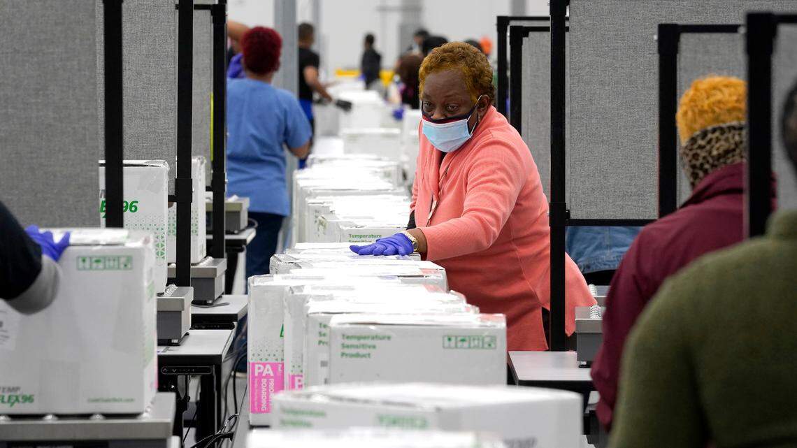 Boxes containing the Moderna COVID-19 vaccine are prepared to be shipped at the McKesson distribution center in Olive Branch, Miss. President-elect Joe Biden plans to invoke the Defense Production Act to increase vaccine production, one of his advisers says.