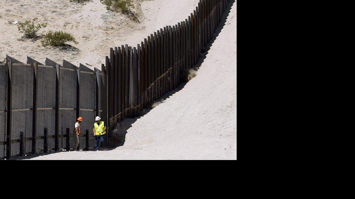A U.S. Army Corps of Engineers official inspects a new section of fencing May 6 near Sunland Park, N.M.