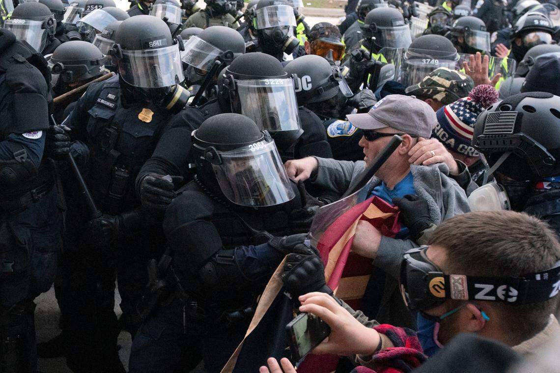 Capitol police officers in riot gear push back a crowd trying to break a door of the U.S. Capitol on Wednesday, Jan. 6, 2021, in Washington. (AP Photo/Jose Luis Magana)