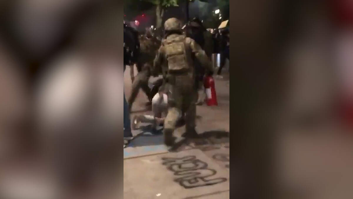 Federal officers arrive after a group of protesters try to set a courthouse on fire in Portland
