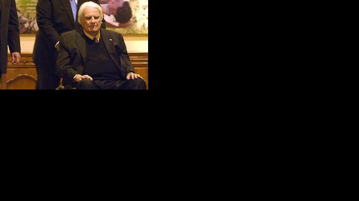 4/20/2010 Franklin Graham, left walks beside his father Billy Graham as they make their way into a dinner at the Billy Graham Evangelistic Association's headquarters Tuesday night.