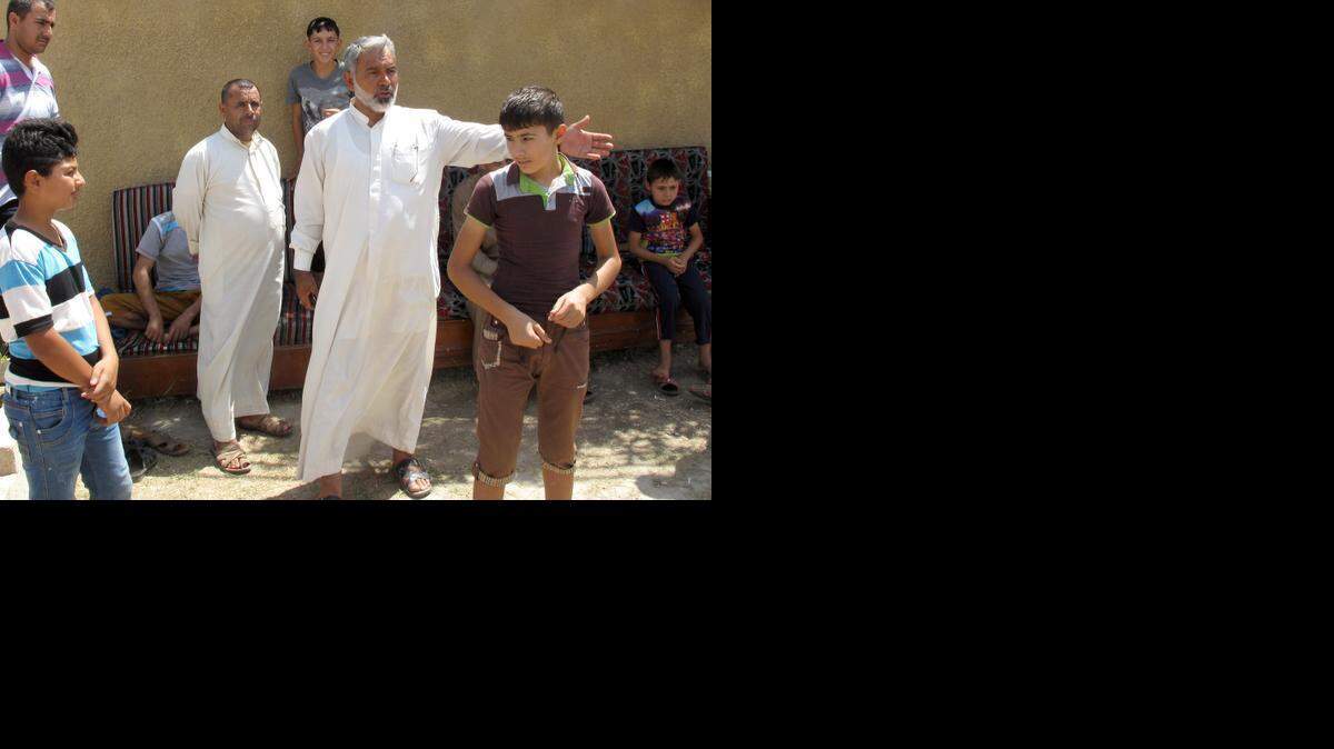 Haider Kadhim, center, is managing a refugee center in Baghdad for Iraqi Turkmen who've been displaced from their homes by Islamic State militants. The refugees says their homes were burned and destroyed in fighting between militants and Kurdish peshmerga in June. (Adam Ashton/McClatchy) 
