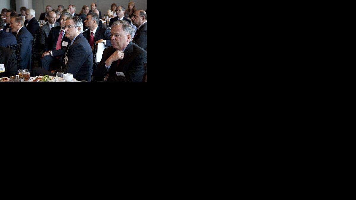 Chevron CEO John Watson, center, and Bechtel Group CEO Riley P. Bechtel, right, listen to Mitt Romney speak during the Business Roundtable quarterly meeting.