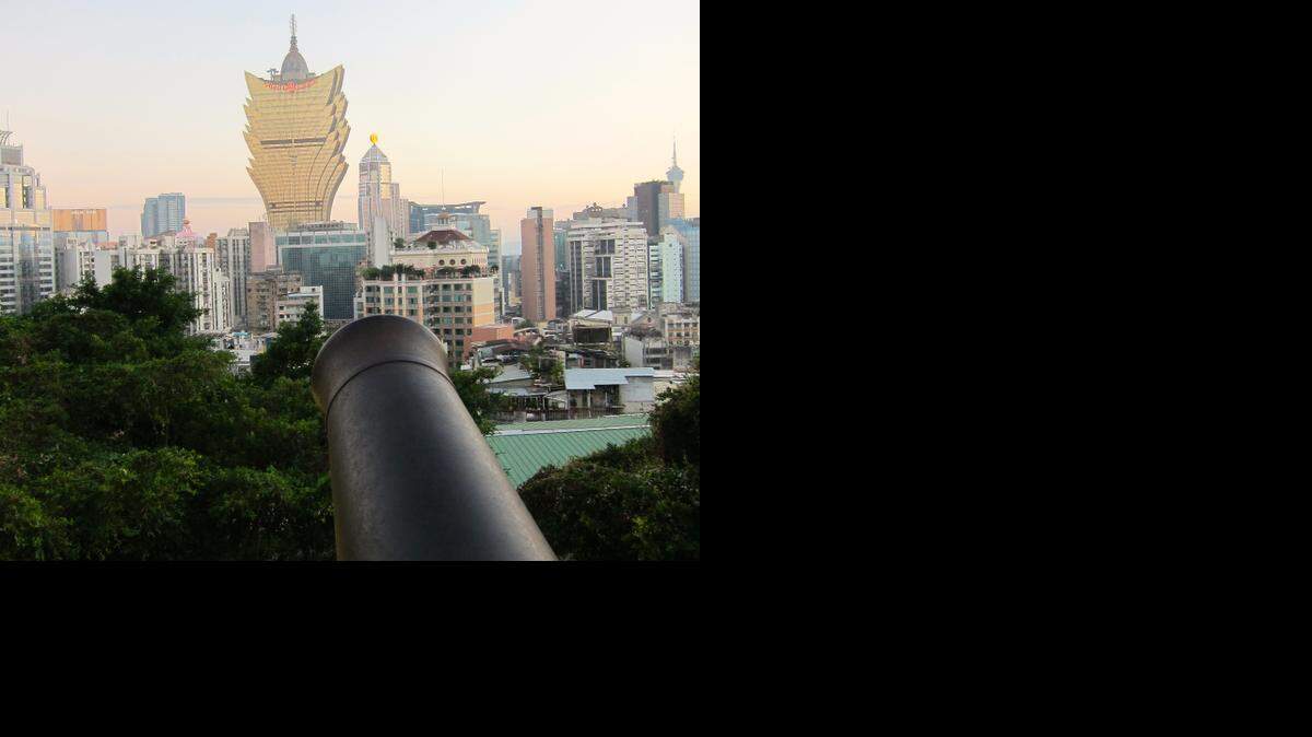 A cannon from the old Portuguese fort points toward the Grand Lisboa hotel and casino, in Macau, China on Nov. 23, 2014. Macau, the only region in China where casino gambling is allowed, has seen its revenues drop the last six months because of Beijing's crackdown on corruption involving government officials.
