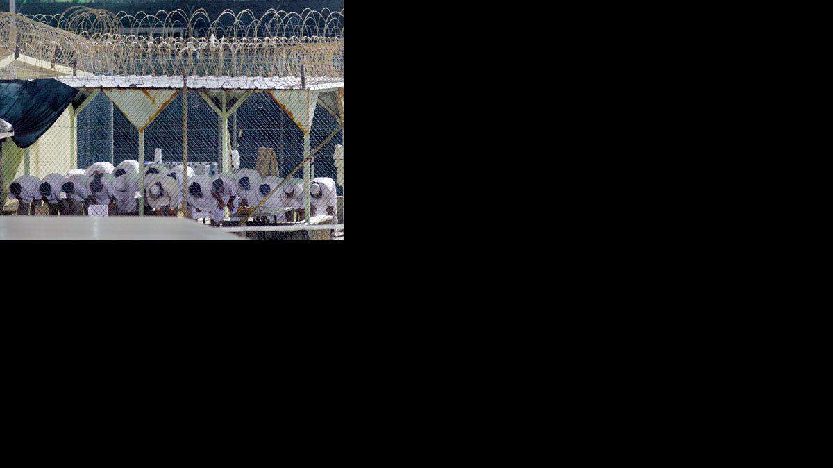 Detainees conduct morning prayers at Guantanamo.