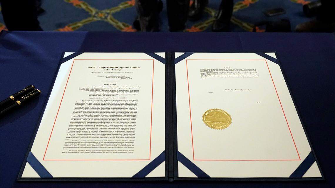 The article of impeachment against President Donald Trump on a table before House Speaker Nancy Pelosi of California, signs it in an engrossment ceremony before transmission to the Senate for trial on Capitol Hill, in Washington, Wednesday, Jan. 13, 2021. Republican lawmakers who voted in favor of impeachment have stood by their decision as the impeachment trial is set to start Tuesday in the Senate.