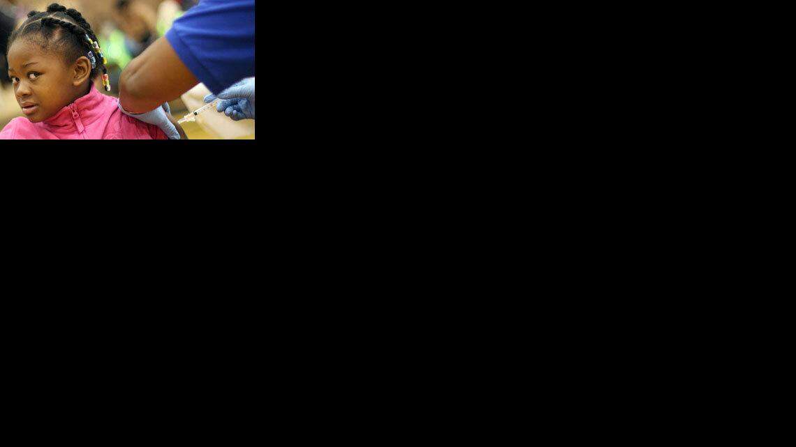 Diondra Reynolds, 6, of Detroit, receives an H1N1 flu vaccination in Hamtramck, Mich.