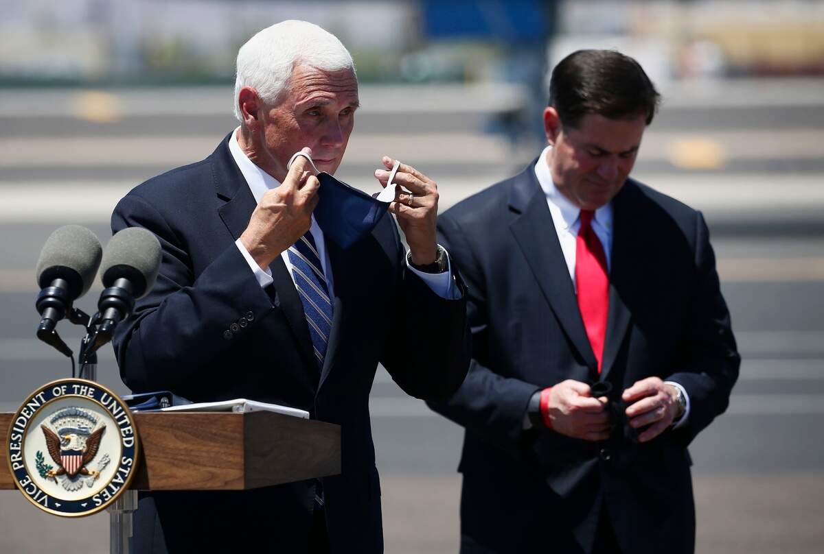 Vice President Mike Pence, left, puts his face mask back on as Arizona Gov. Doug Ducey does the same after a news conference to discuss their meeting on the surge in coronavirus cases in Arizona Wednesday, July 1, 2020, in Phoenix. (AP Photo/Ross D. Franklin)