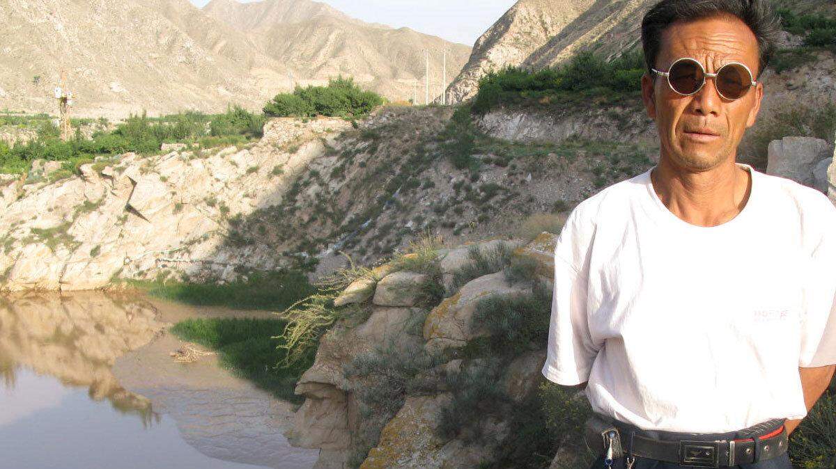 Wei Jinpeng stands at the spot where he keeps dead bodies tied up in the Yellow River near Changpo Village in China's Gansu Province. Wei makes a living selling the bodies to families who come to claim them. (Tom Lasseter/MCT)