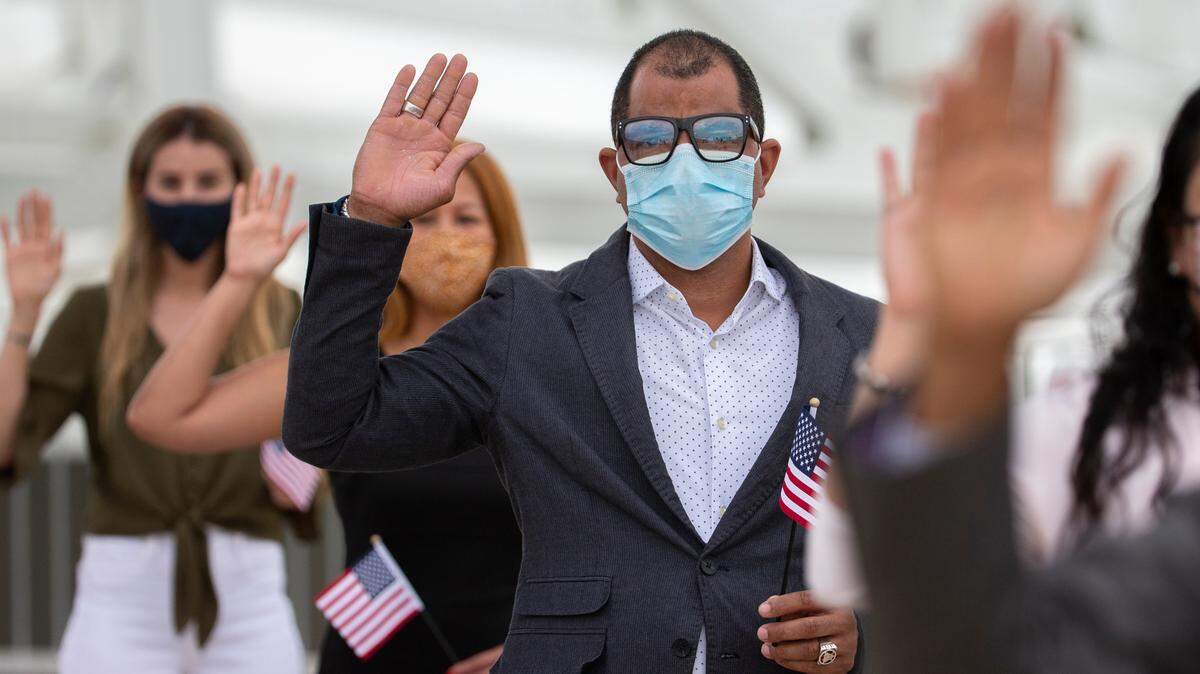 One of 51 Florida residents says the Pledge of Allegiance at a naturalization ceremony during halftime of an NFL football game between the Jacksonville Jaguars and the Cleveland Browns, Sunday, Nov. 29, 2020, in Jacksonville, Fla. This year’s participants originate from 24 countries spanning the globe. The Jaguars are the only team in the NFL to host a naturalization ceremony. (AP Photo/Stephen B. Morton)