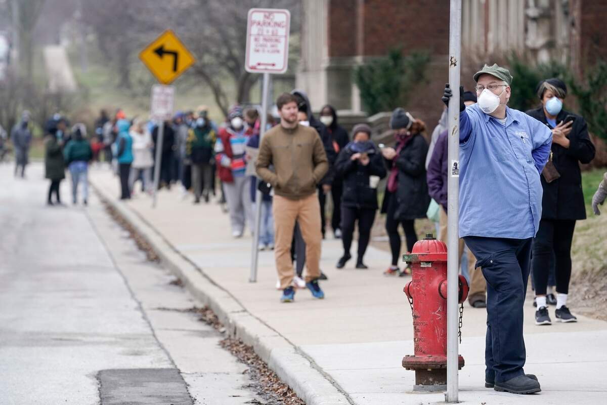 Voters masked against coronavirus line up at Riverside High School for Wisconsin’s primary election Tuesday April 7, 2020, in Milwaukee. The new coronavirus causes mild or moderate symptoms for most people, but for some, especially older adults and people with existing health problems, it can cause more severe illness or death. (AP Photo/Morry Gash)